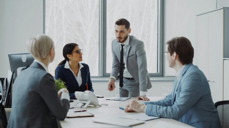 Professionals engaged in a serious business discussion in a bright office environment.